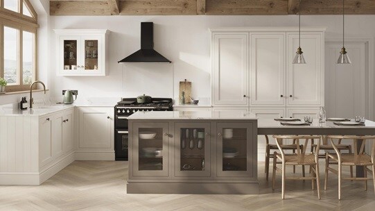 A porcelain shaker kitchen from Ilfracombe, in an l-shaped layout. It has a mushroom-toned island with glass base cabinets.