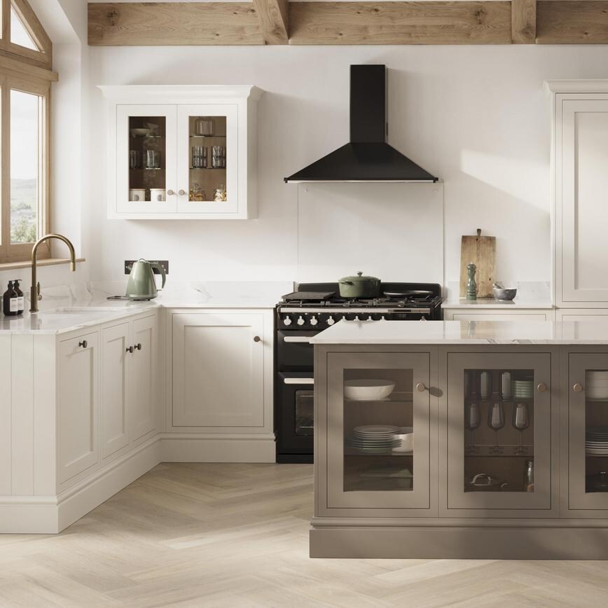 A porcelain shaker kitchen from Ilfracombe, in an l-shaped layout. It has a mushroom-toned island with glass base cabinets.