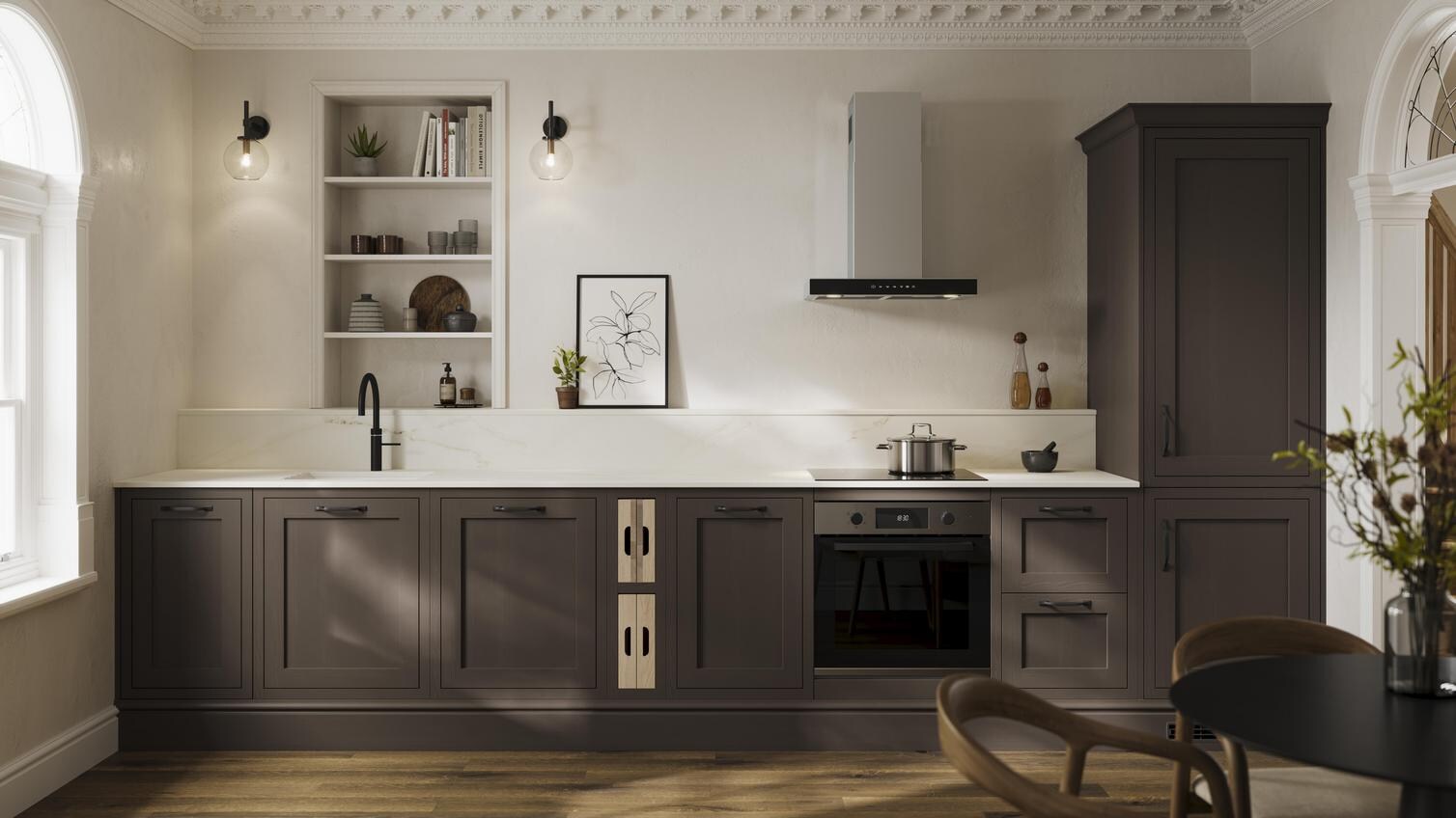 A brown shaker kitchen from Ilfracombe Truffle, in a single wall layout. It has black accessories and dark oak flooring.