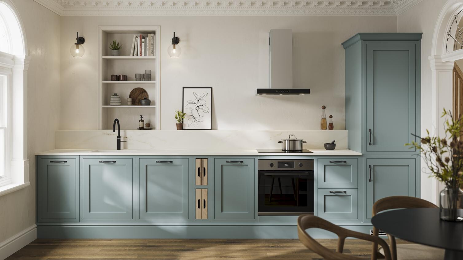 A blue shaker kitchen from Ilfracombe Seafoam, in a single wall layout. It has a black tap, accessories, and oak flooring. 