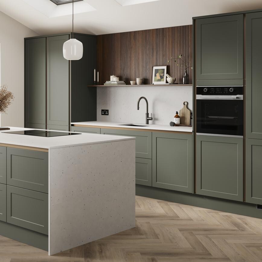 An ash green, shaker kitchen island in a matt finish & handleless style. It has quartz worktops with side panels & backboard