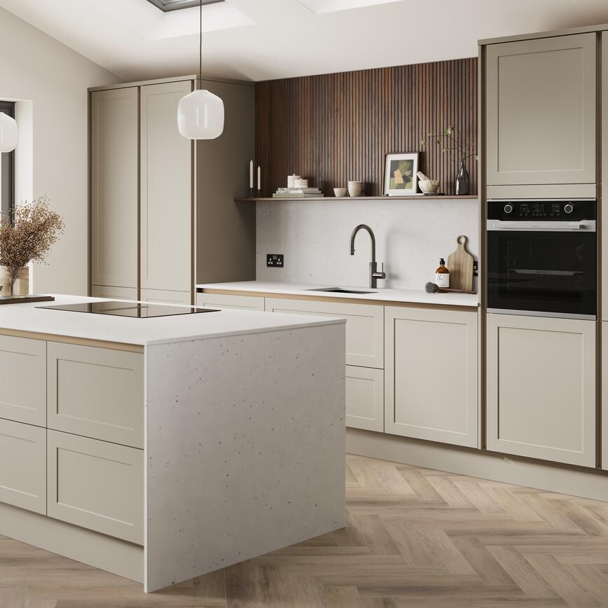 A handleless, sanstone shaker kitchen island in a matt finish. It has quartz worktops with side panels and backboard. 