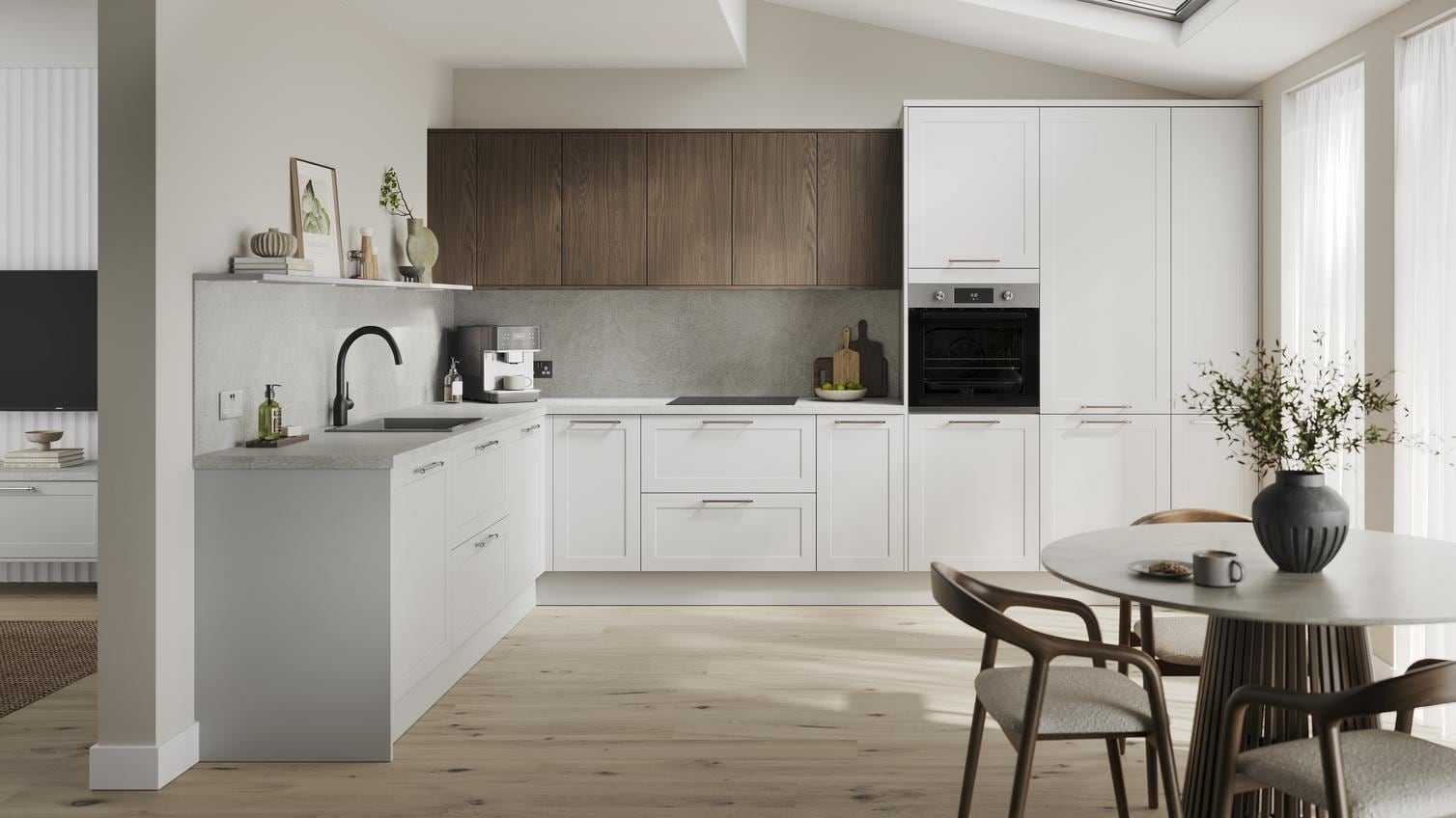 An l-shaped kitchen in a dove grey finish from the Frome collection. It has pale oak flooring and dark oak wall cabinets. 