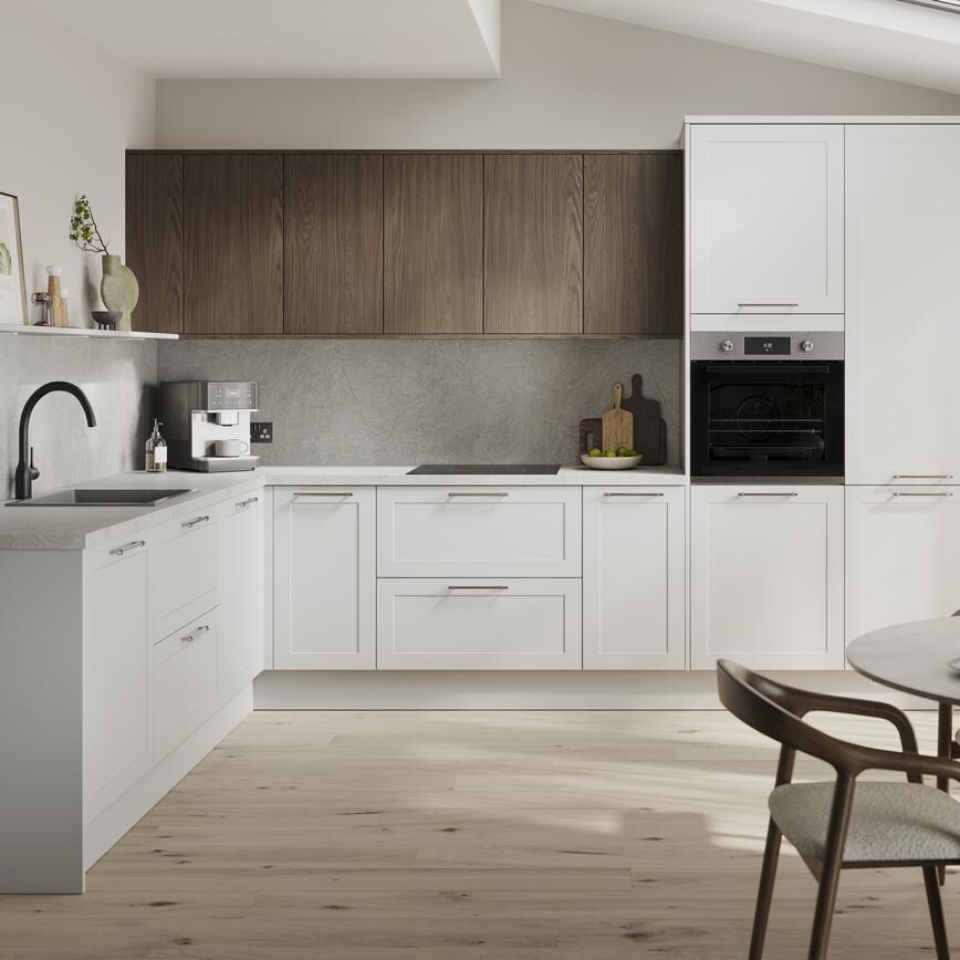 An l-shaped kitchen in a dove grey finish from the Frome collection. It has pale oak flooring and dark oak wall cabinets. 