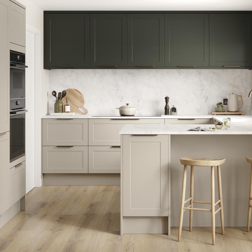 A shaker, sandstone kitchen in a peninsula layout from the Frome range. It has oak plank flooring and green wall cabinets. 