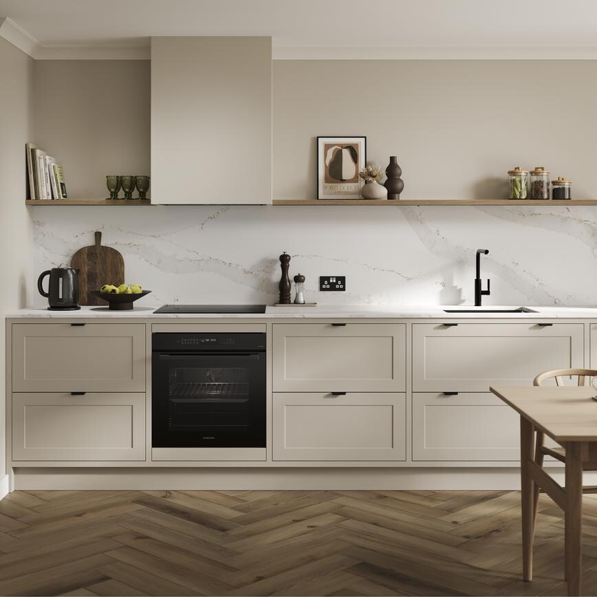 An in-frame shaker, sandstone kitchen in peninsula layout from the Frome range. It has oak plank flooring & green wall units
