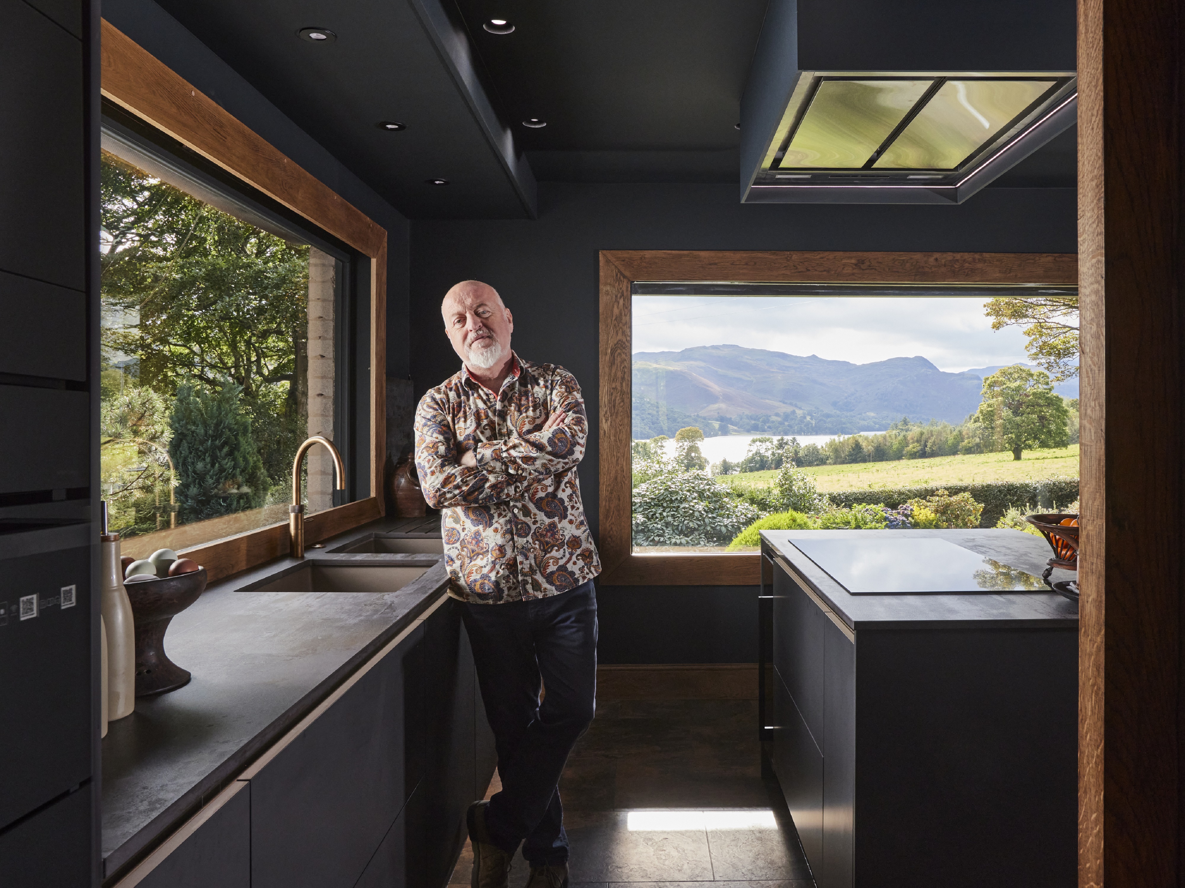 Bill standing in his kitchen in front of the view of the Lake District