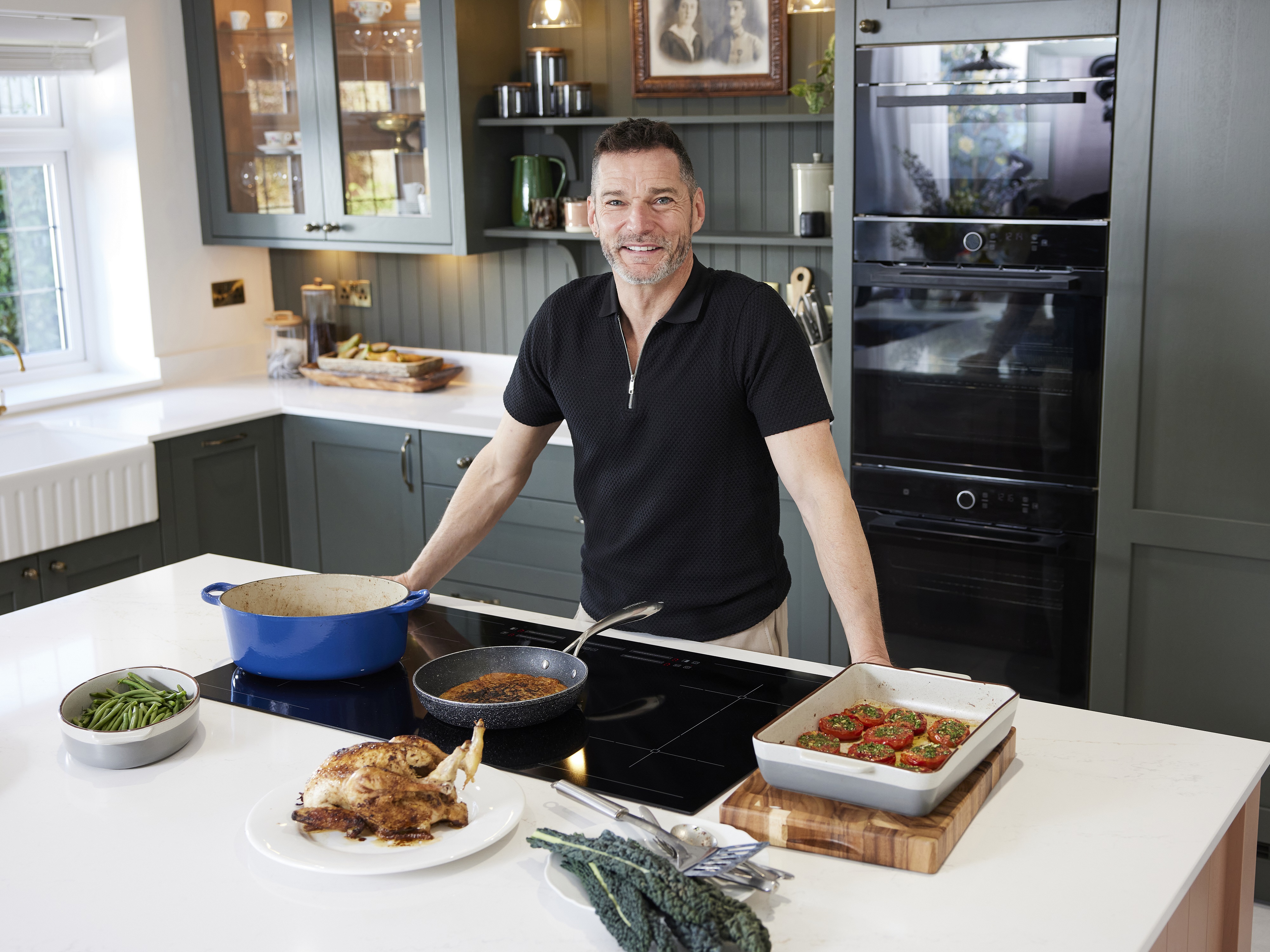 Fred stood at his induction hob, smiling and cooking