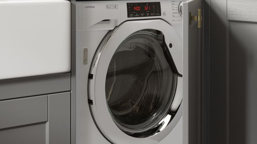 Integrated washing machine with a light grey shaker door and wooden counter tops.