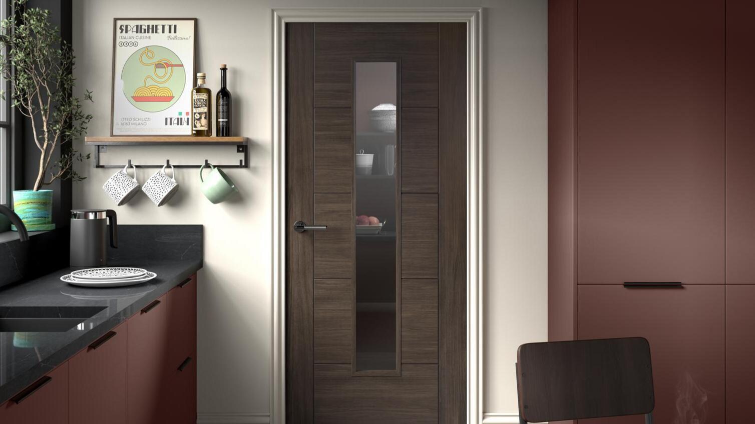 A walnut kitchen door with a black cabinet handle inside a dramatic, slab cooking space.