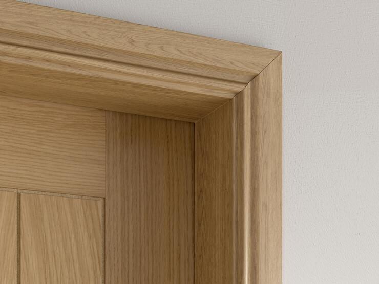 Close up of a warm oak architrave surrounding a matching coloured door
