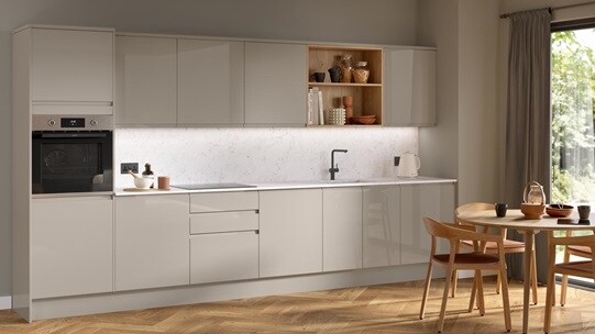 A cream, sandstone Clerkenwell kitchen, in a single wall layout and with j-pull handles. It also has marble-style counters.