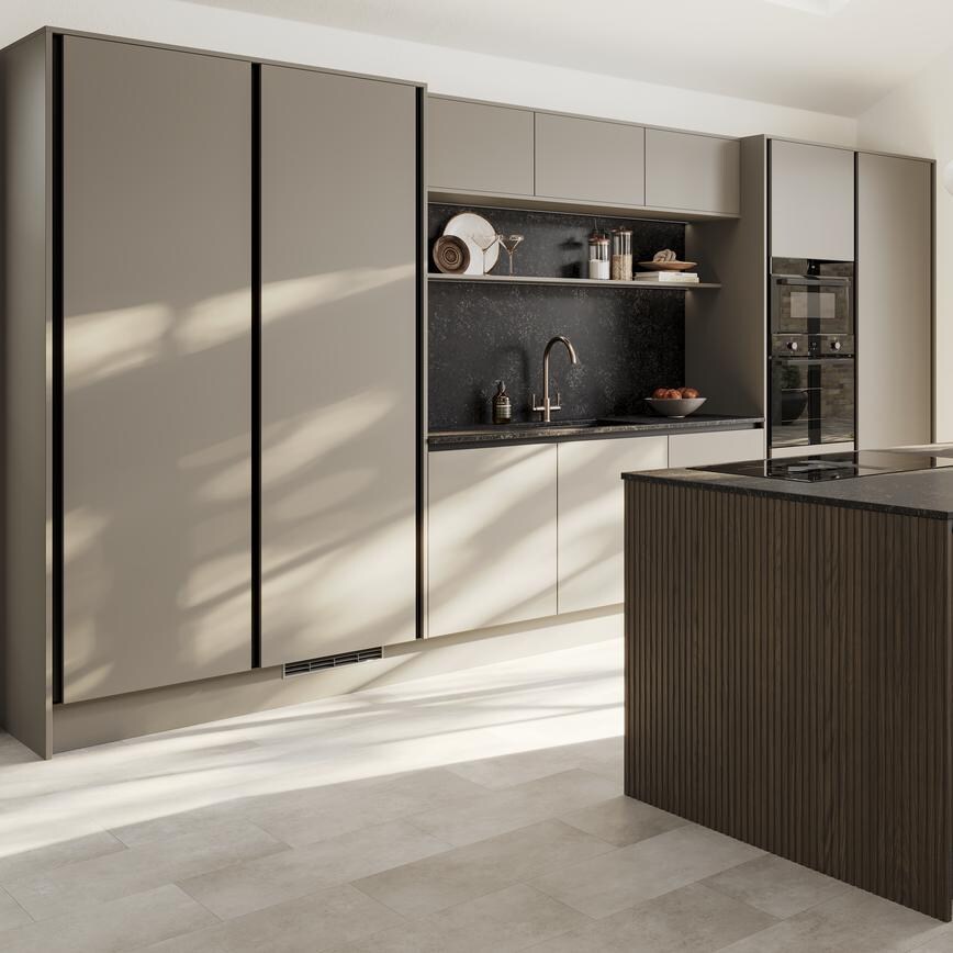 A sand grey kitchen with a slab design. It has a single wall layout with island. Black worktops and profiles also feature.