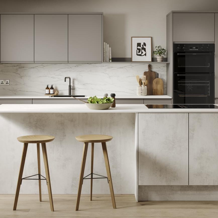 A slab, white stone kitchen in a single-wall layout with a textured finish. It has oak wall cabinets and a white worktop. 