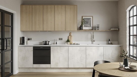 A slab kitchen island layout in a textured white stone finish. It also has grey cabinets on one wall & marble-style surfaces.