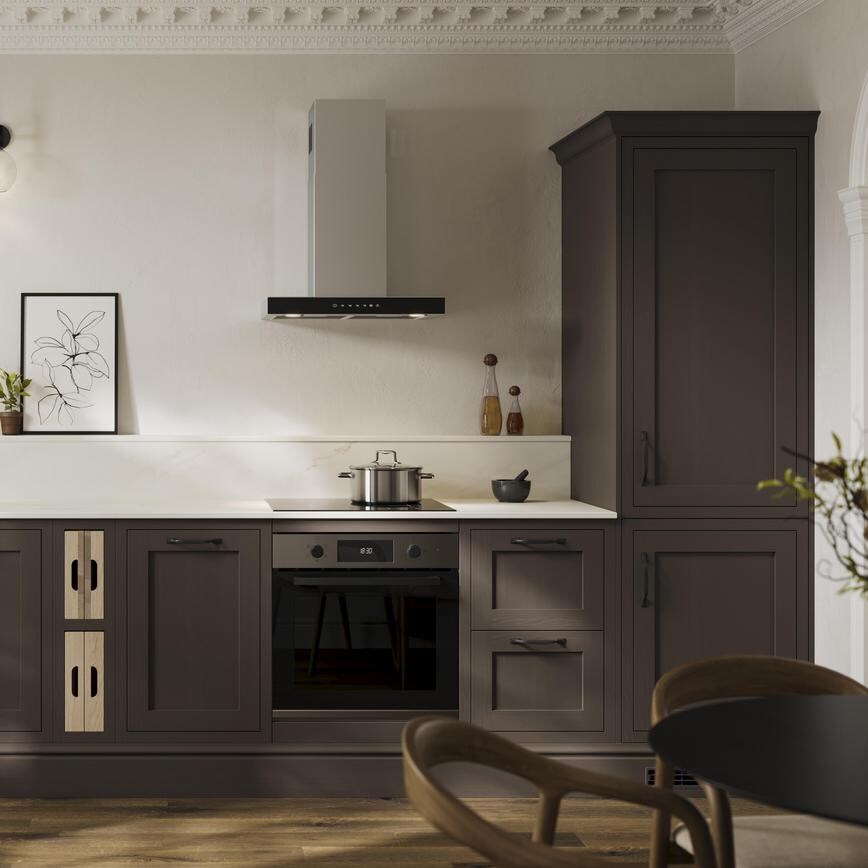 A brown shaker kitchen from Ilfracombe Truffle, in a single wall layout. It has black accessories and dark oak flooring.