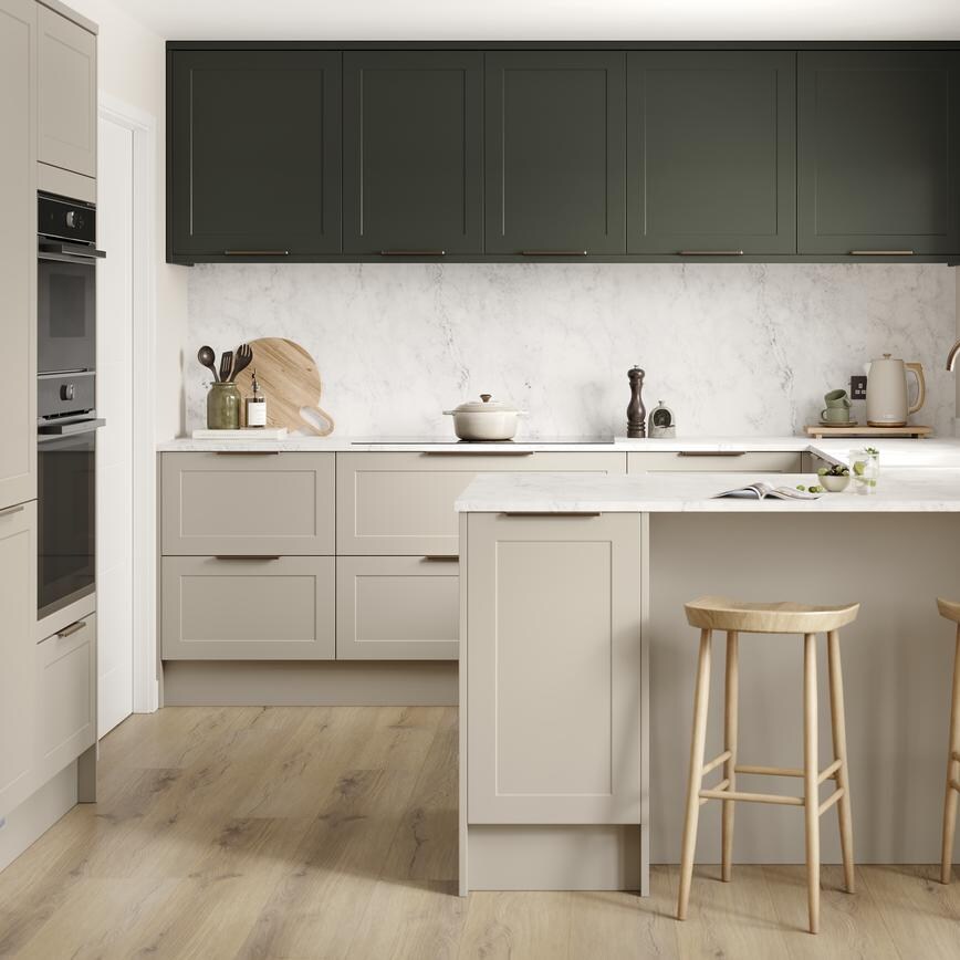 A shaker, sandstone kitchen in a peninsula layout from the Frome range. It has oak plank flooring and green wall cabinets. 