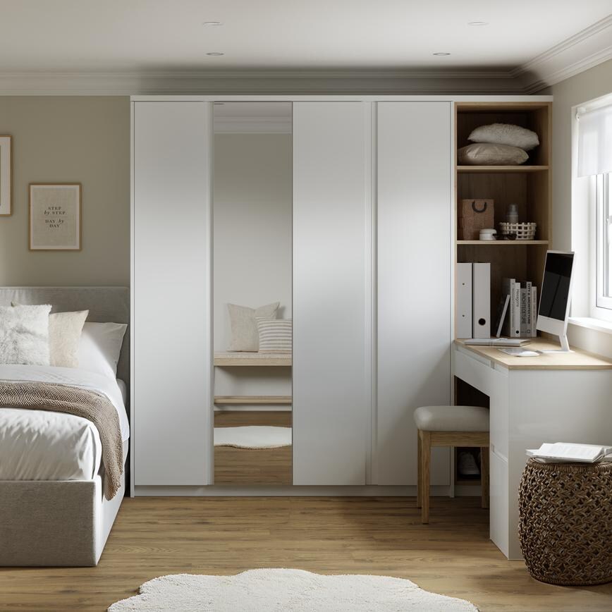 A gloss white bedroom with shelves and mirrored wardrobe door. The room has warm oak-style flooring and a matching dresser.