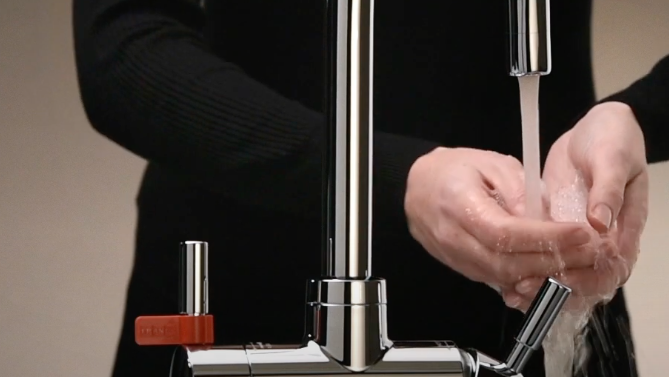 Person washing hands under a Franke tap